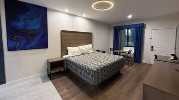 Een moderne hotelkamer met een groot bed, een bureau en een stoel.