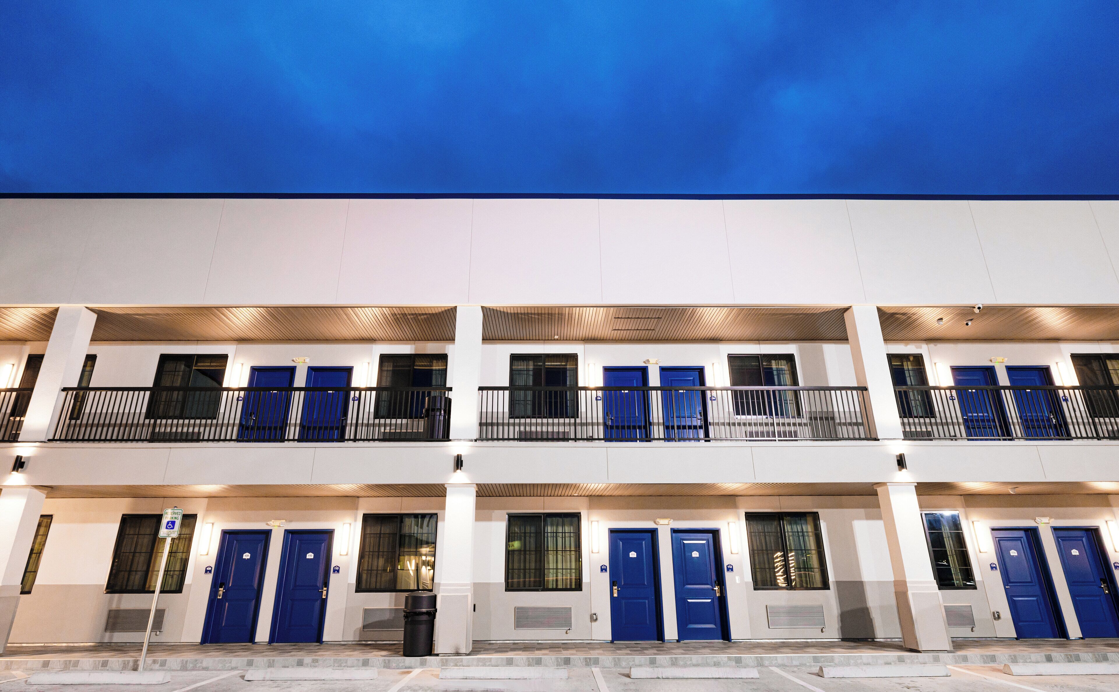 A multi-story hotel with blue doors and balconies.