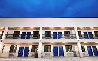 A multi-story hotel with blue doors and balconies.