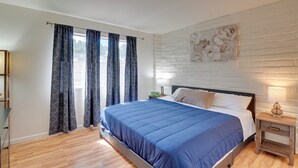 A bedroom with a bed, curtains, a nightstand, and a wall-mounted artwork. - Wildcats Welcome! Mtn-View Condo 7 Mi to U of A (Tucson)
