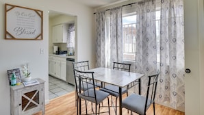 A dining area with a marble table and metal chairs, a small side table with a plant, and a kitchen in the background. - Wildcats Welcome! Mtn-View Condo 7 Mi to U of A (Tucson)