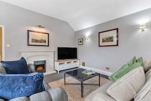 A living room with a fireplace, television, and two sofas.