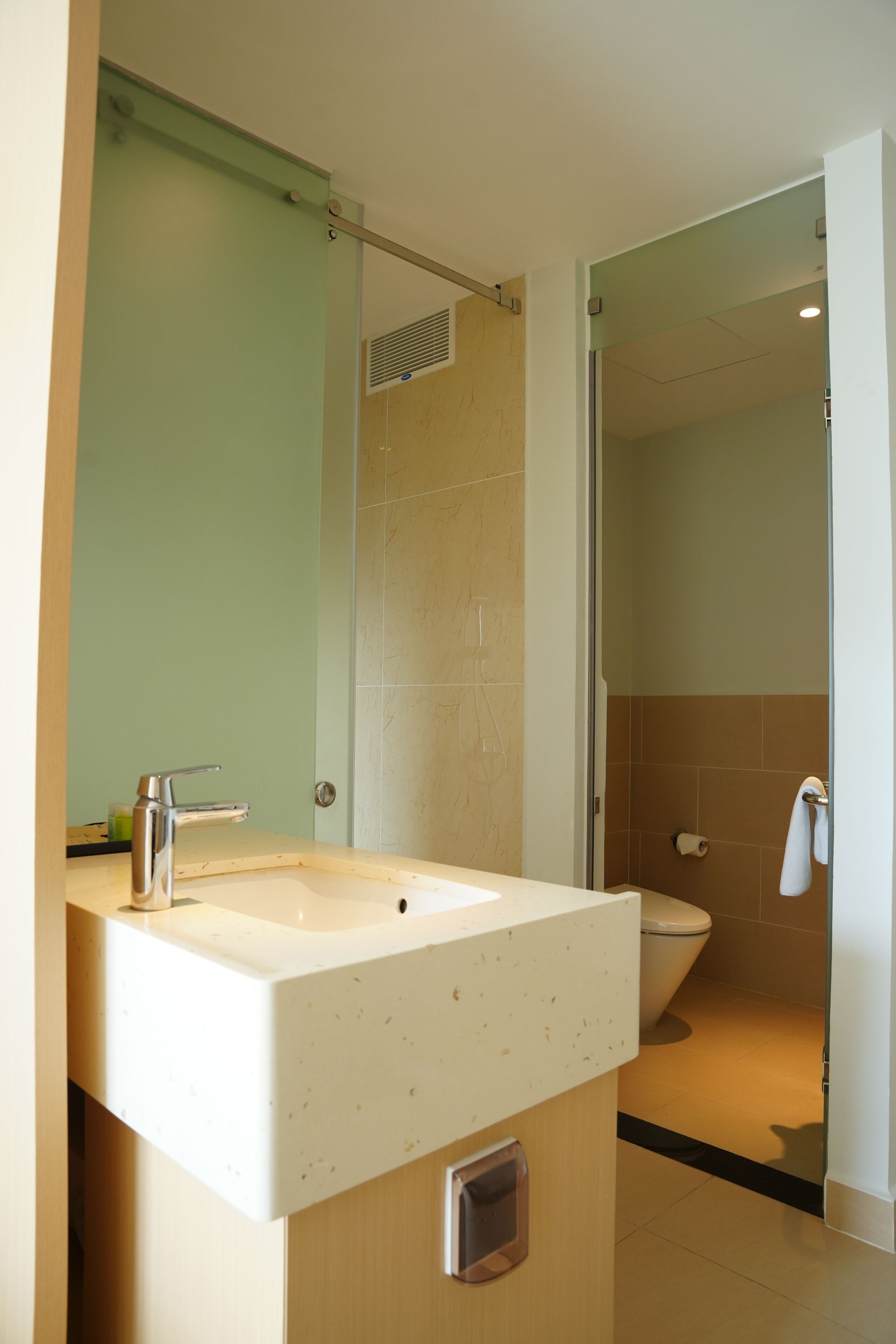 A modern bathroom with a white sink, a mirror, and a shower area.