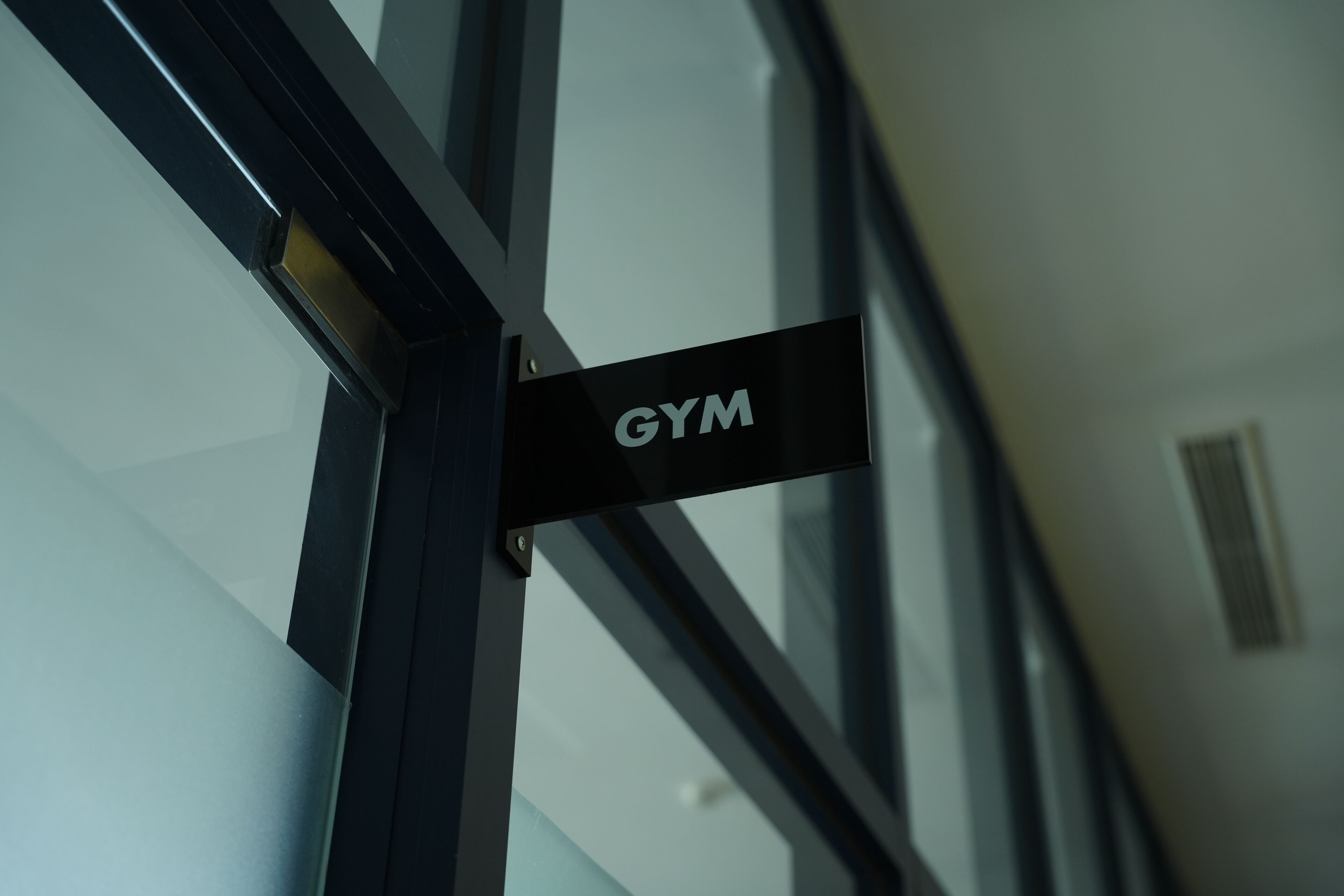 Ein Schild mit der Aufschrift 'GYM', das auf einen Fitnessbereich hinweist.