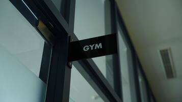 Ein Schild mit der Aufschrift 'GYM', das auf einen Fitnessbereich hinweist.