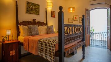 Relax in this inviting bedroom with a large bed, wooden headboard, and framed artwork.
