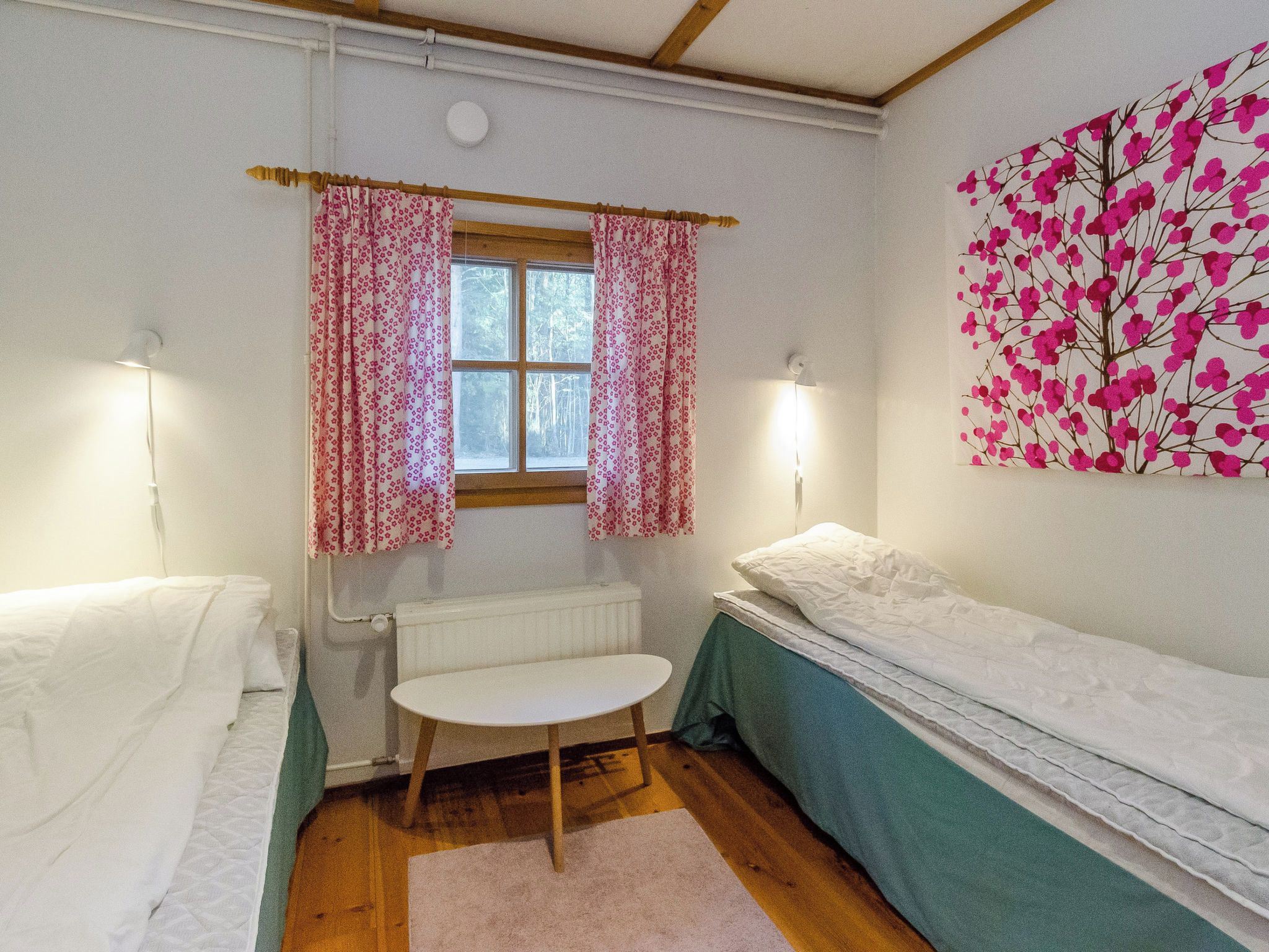 Una habitación pequeña y acogedora con una cama individual, una mesita y un radiador.