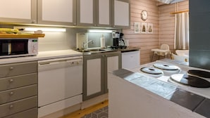Eine kleine Küche mit Mikrowelle, Kaffeemaschine und Spüle.
