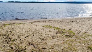 Ein Strand mit sandigem Ufer und ruhigem Wasser.