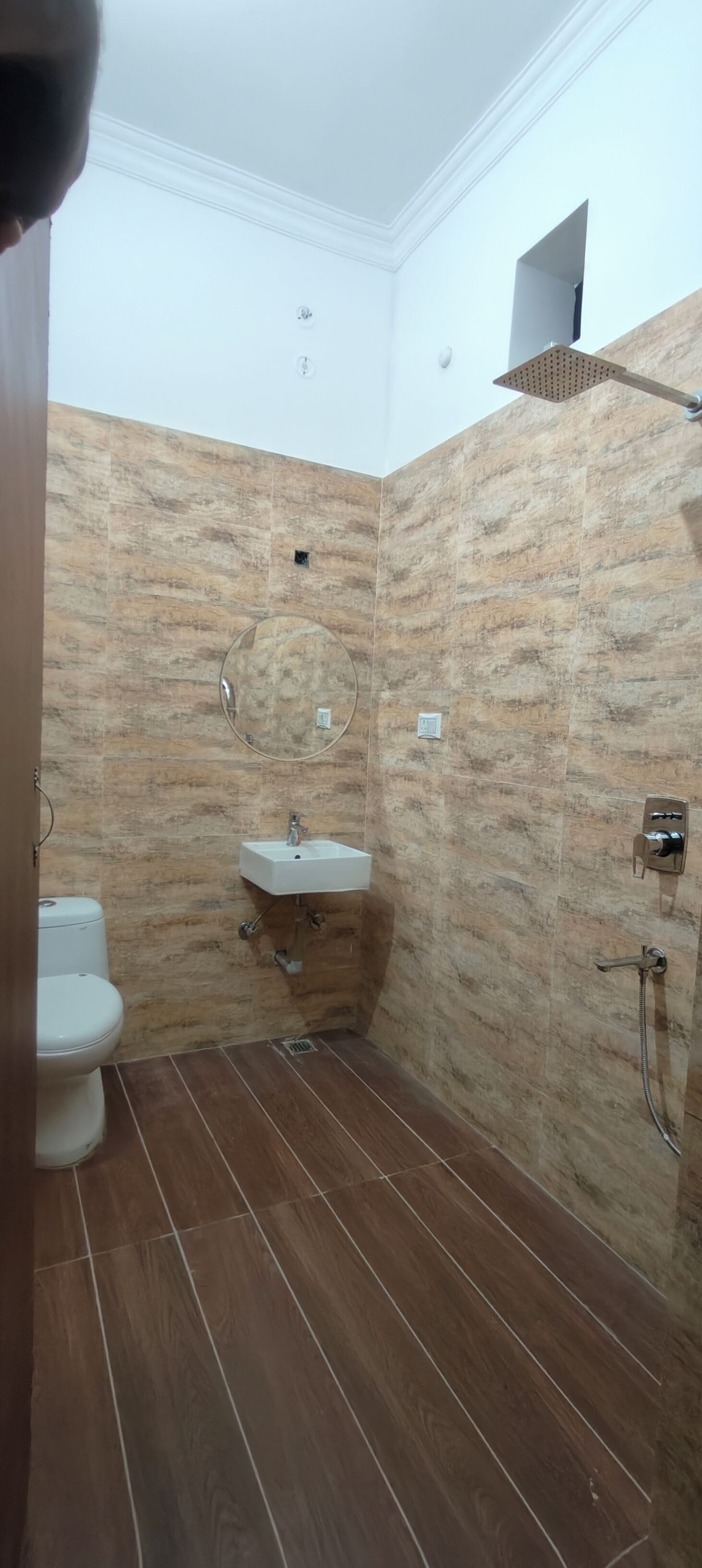 A bathroom with a toilet, sink, and shower.