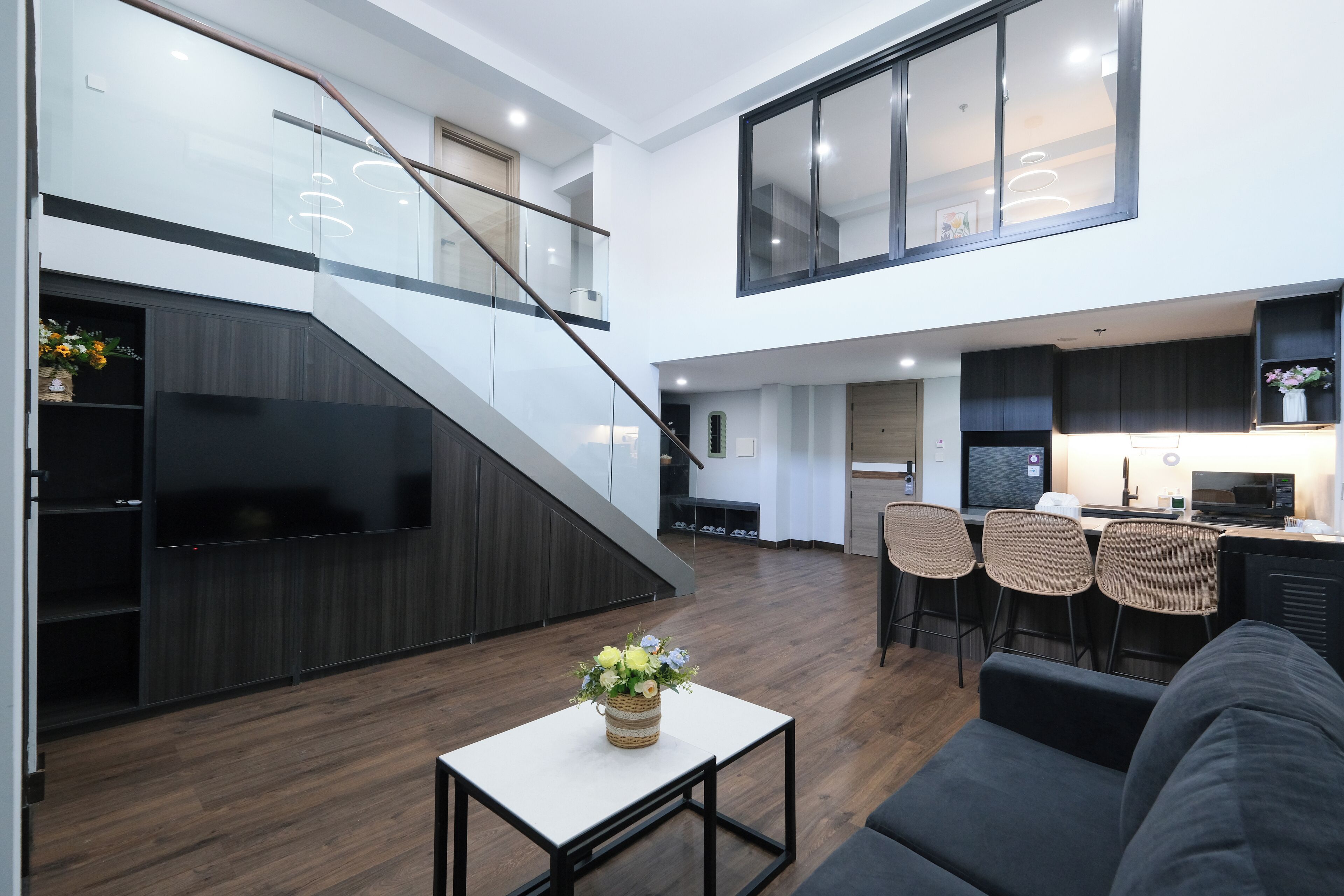 Ein modernes Interieur mit Treppe, Küchenbereich und einer Sitzecke mit Tisch und Stühlen.