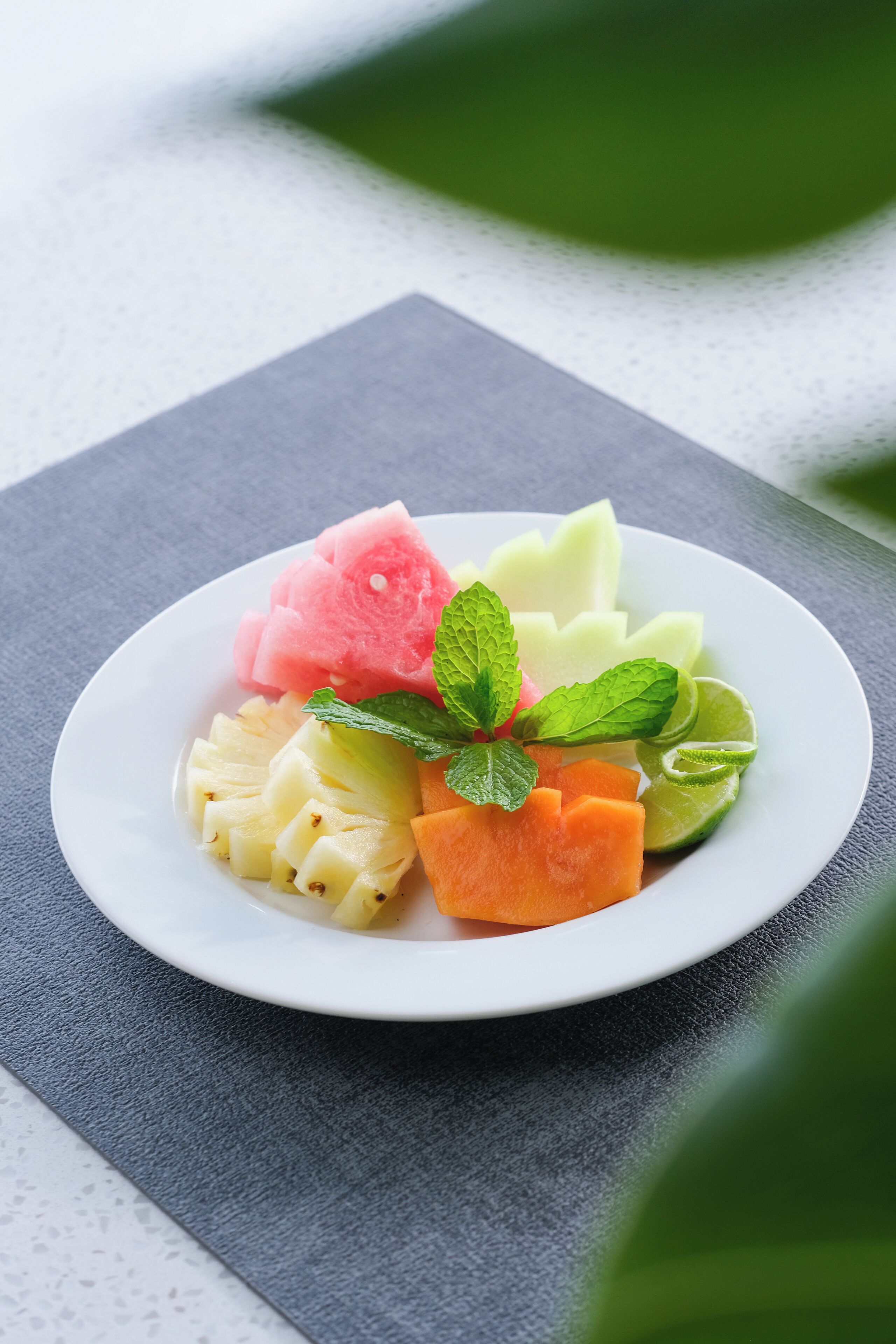 Une assiette remplie de fruits variés est posée sur une table.