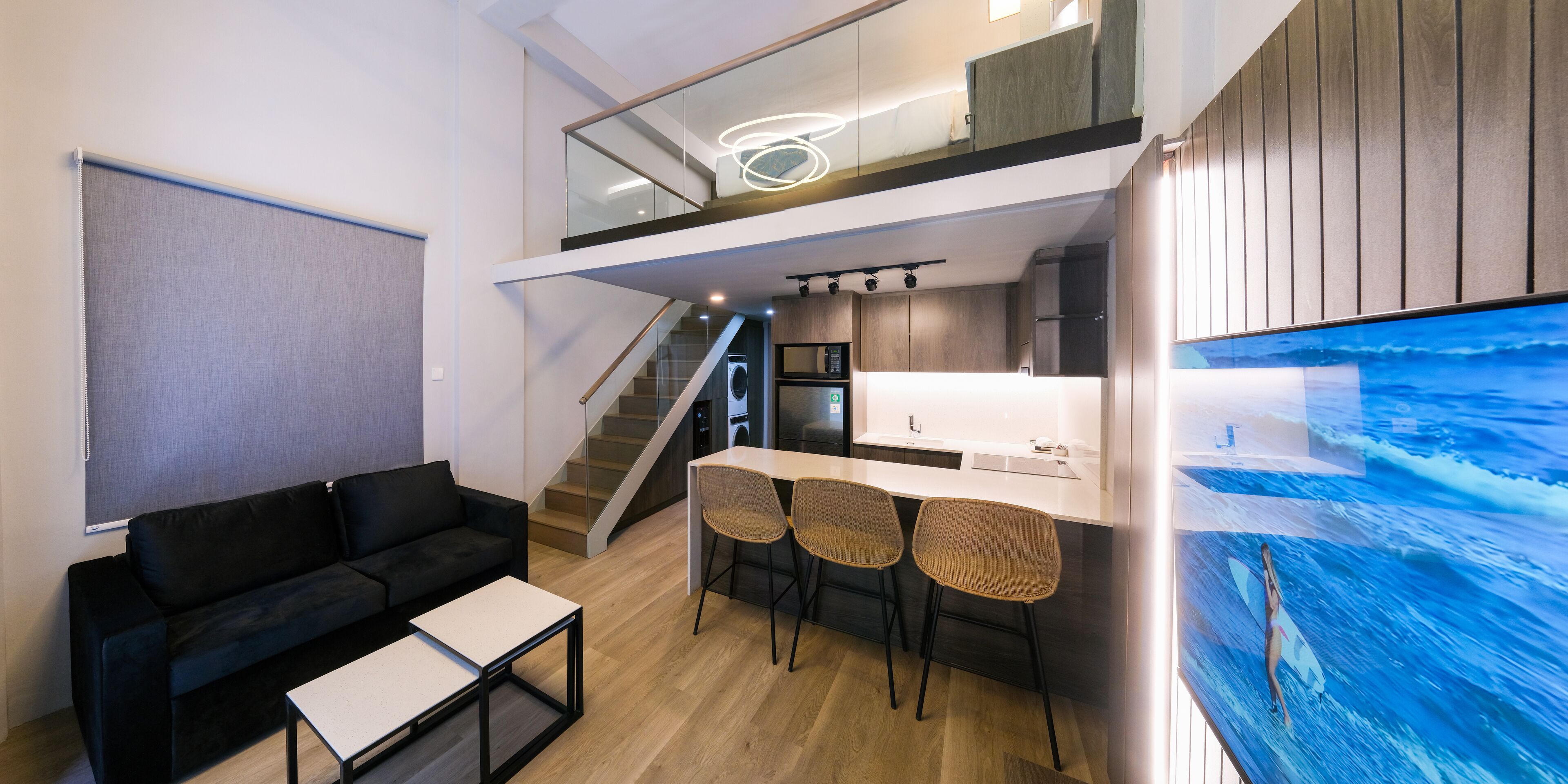 A modern apartment with a living area, kitchenette, and a dining space.