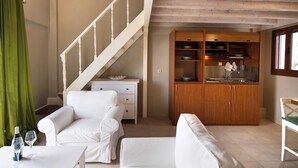 A compact living space with a staircase, a kitchenette, and seating areas. - NV Seafront Studios AV Properties (Lefkada)