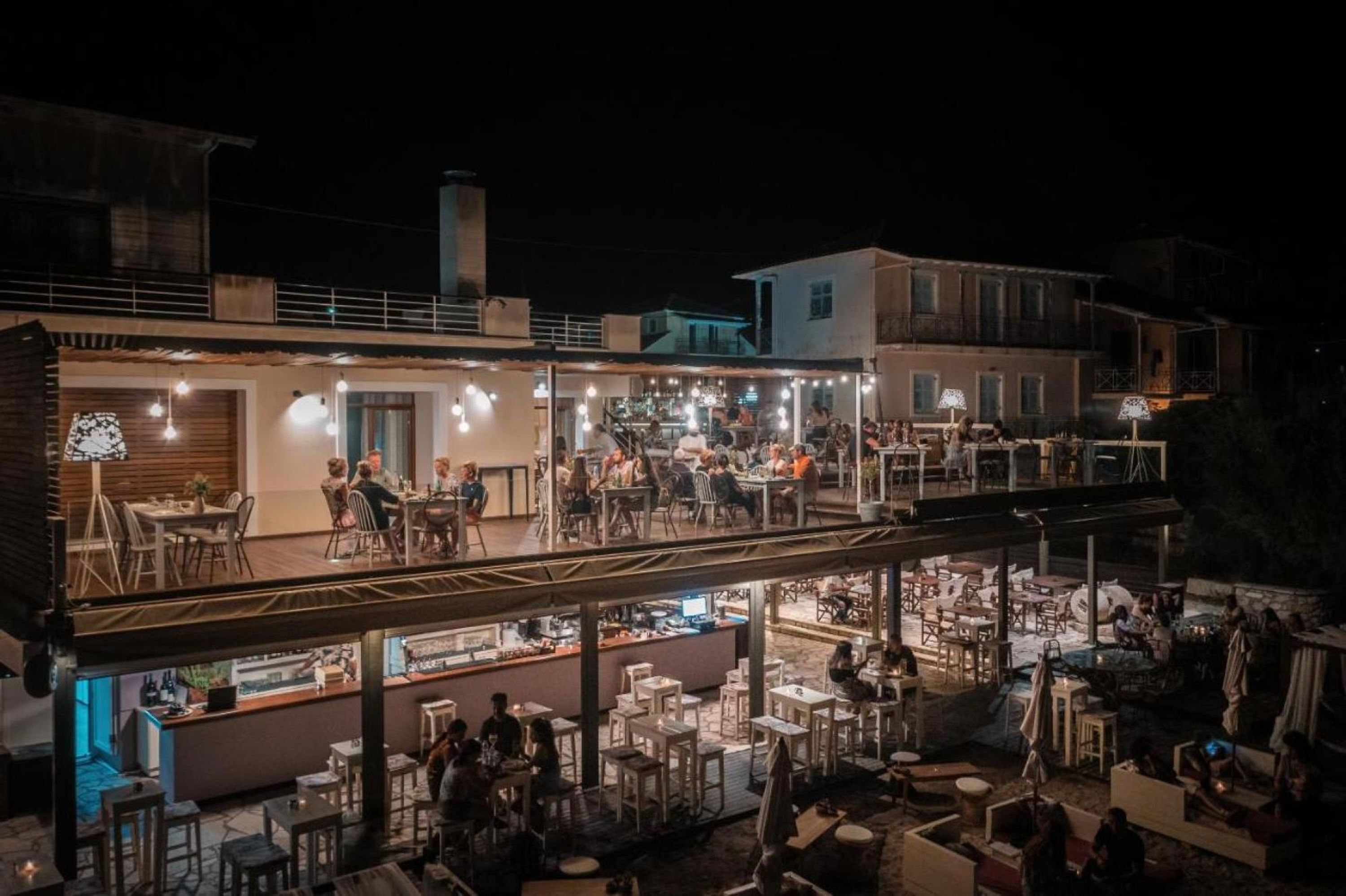 A restaurant with outdoor seating, a bar area, and a covered patio.
