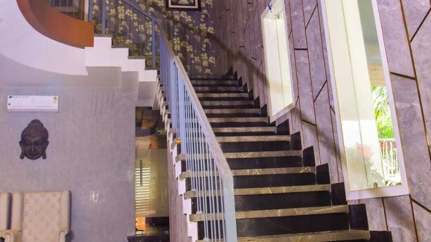 Un escalier en colimaçon avec une rampe en métal, menant à un palier d’où l’on peut admirer la vue sur l’extérieur.