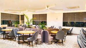 Un restaurant moderne avec des tables rondes et des sièges rembourrés.