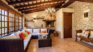 Una sala acogedora con un sofá, una mesa de centro y paredes de piedra.