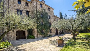 Un edificio de piedra con un patio, una puerta de madera y una planta en maceta.