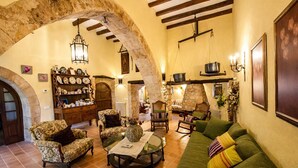 Una sala de estar acogedora con un arco de piedra, muebles de madera y una chimenea.