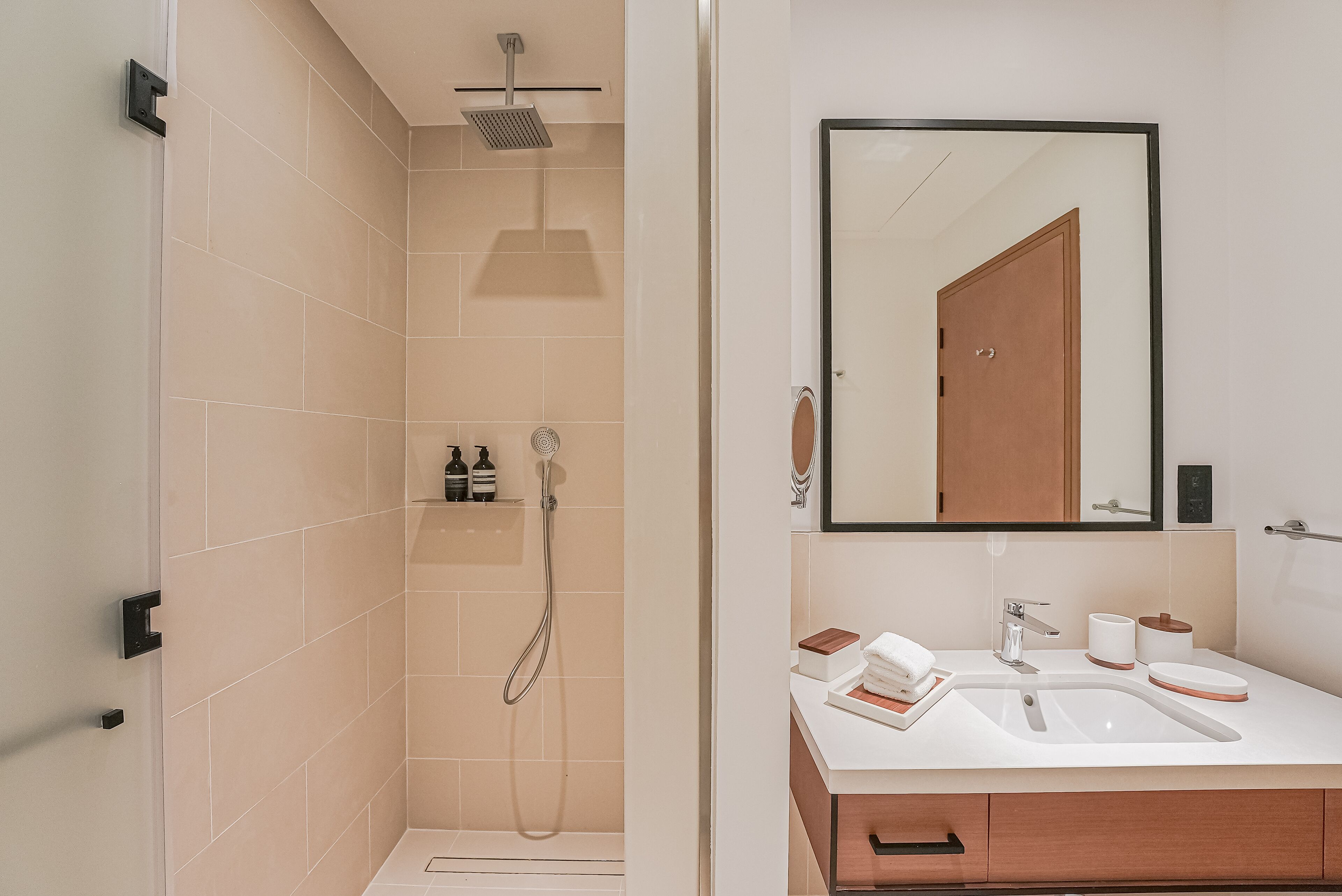 Ein modernes Badezimmer mit Dusche, Waschbecken und Spiegel.