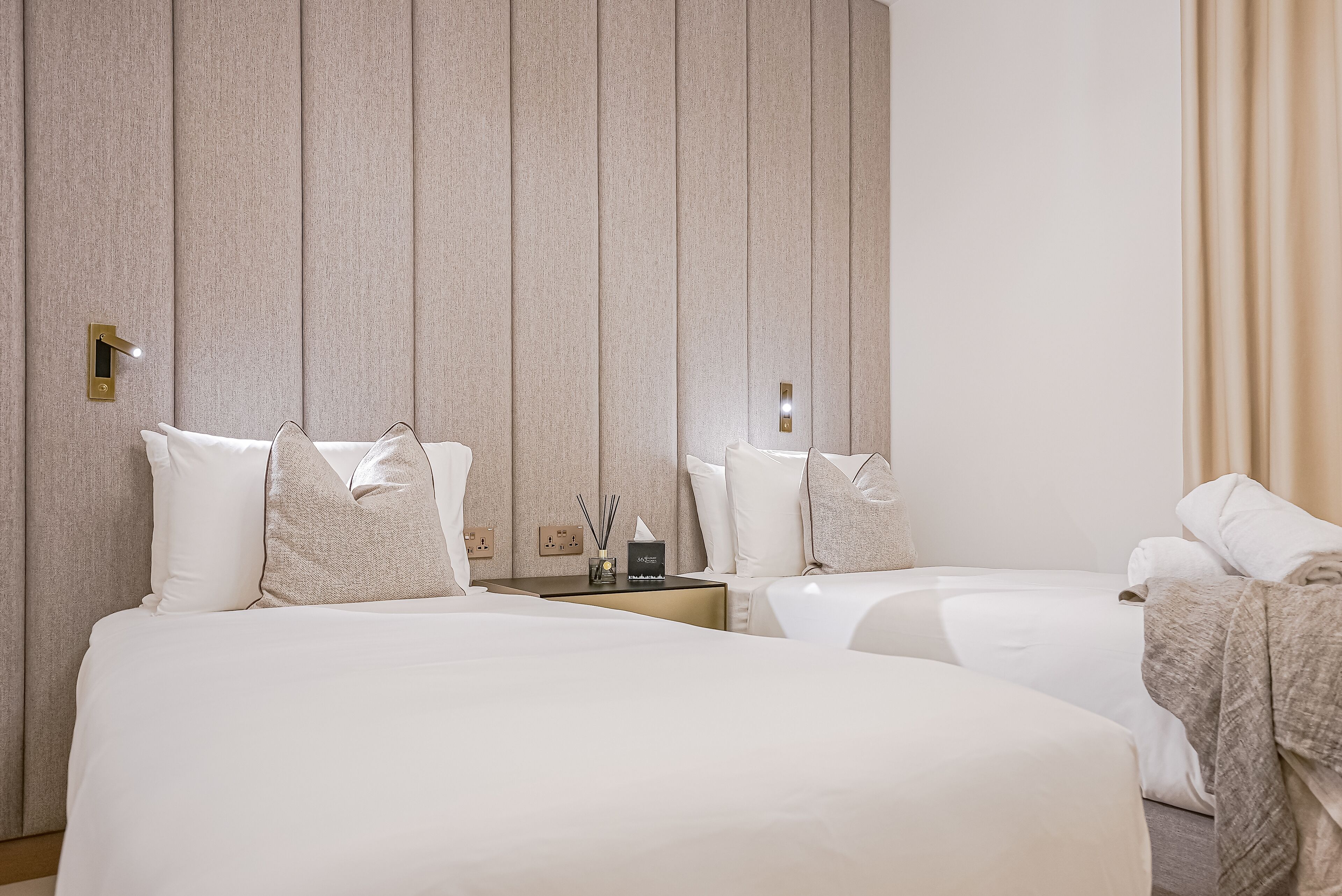 Une chambre d’hôtel avec deux lits, une table de chevet et un miroir.