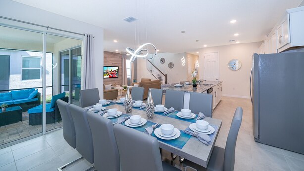 Eine moderne Küche mit Essbereich, einer Treppe und einem Wohnzimmer mit Fernseher.