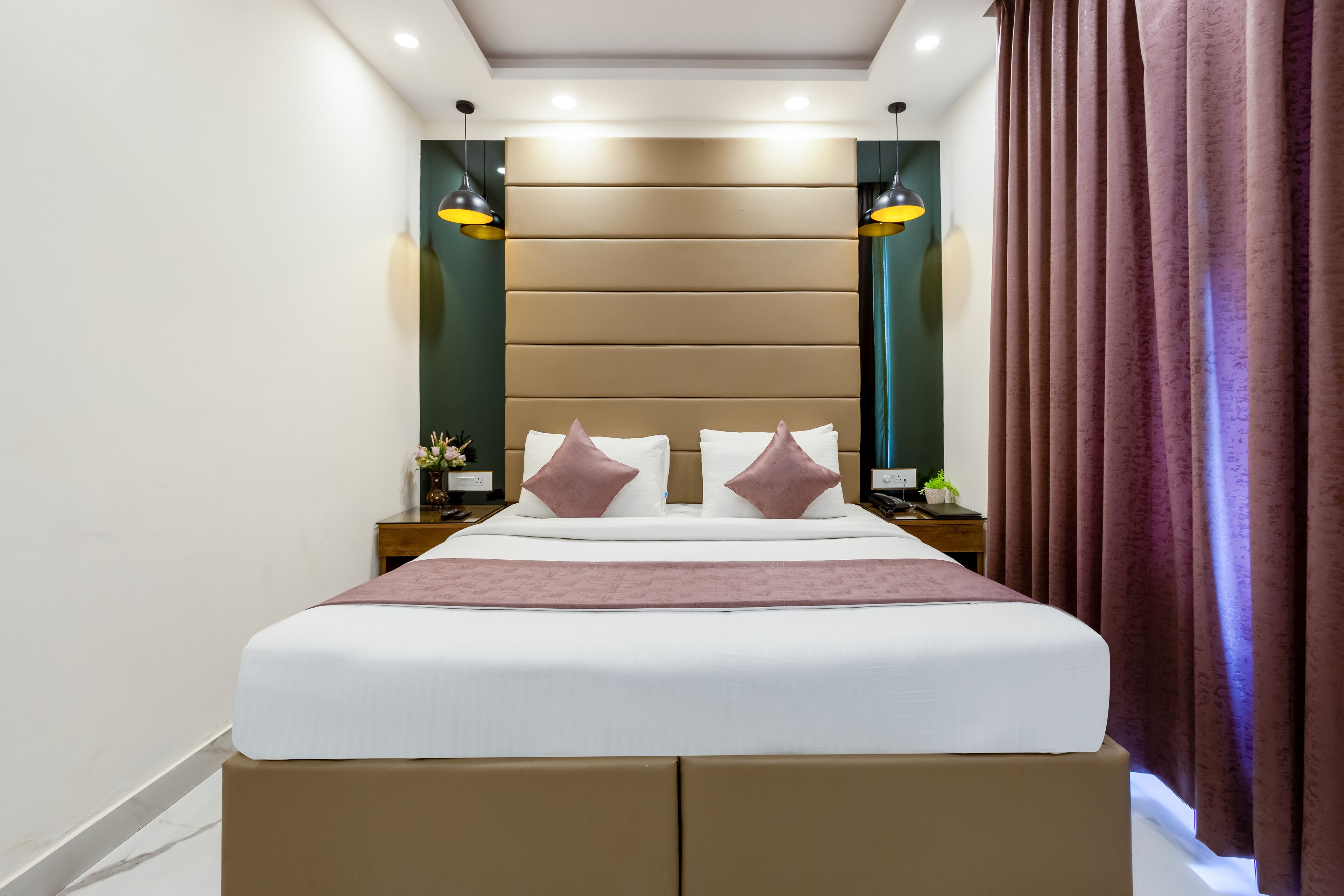 A neatly arranged hotel room with a large bed, two bedside tables, a headboard, and a window with curtains.