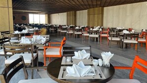 A spacious dining area with multiple tables and chairs, arranged in rows. - Johnny Nguyen - Victor Condotel Phu Yen (Tuy Hoa)