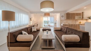 Ein modernes Wohnzimmer mit einer Sofagarnitur, einem Couchtisch und einer Pendelleuchte.