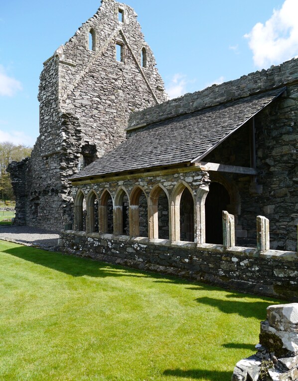 A stone building with a tower and arched windows.