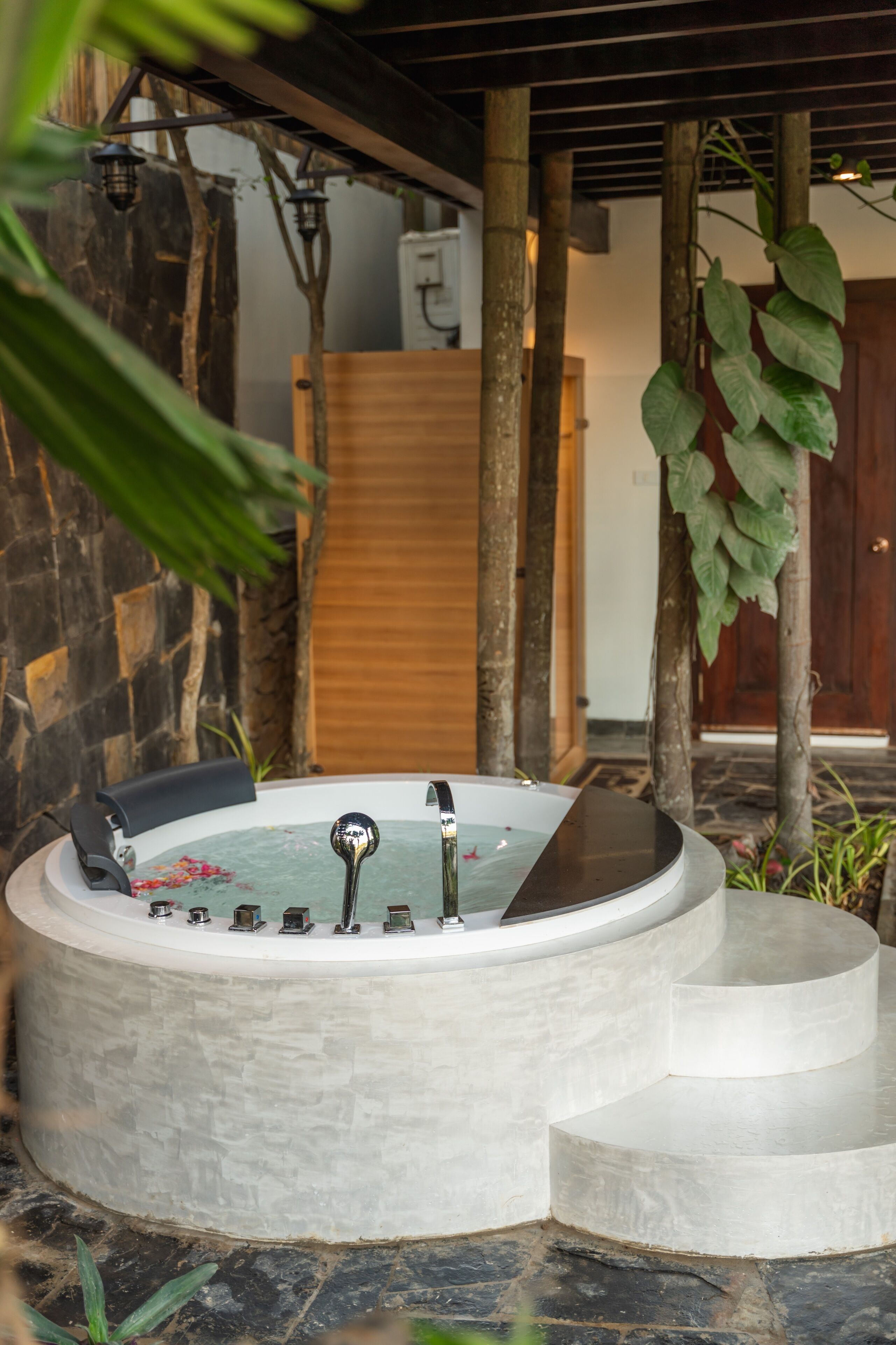 A spa area with a hot tub, stone walls, and wooden elements.