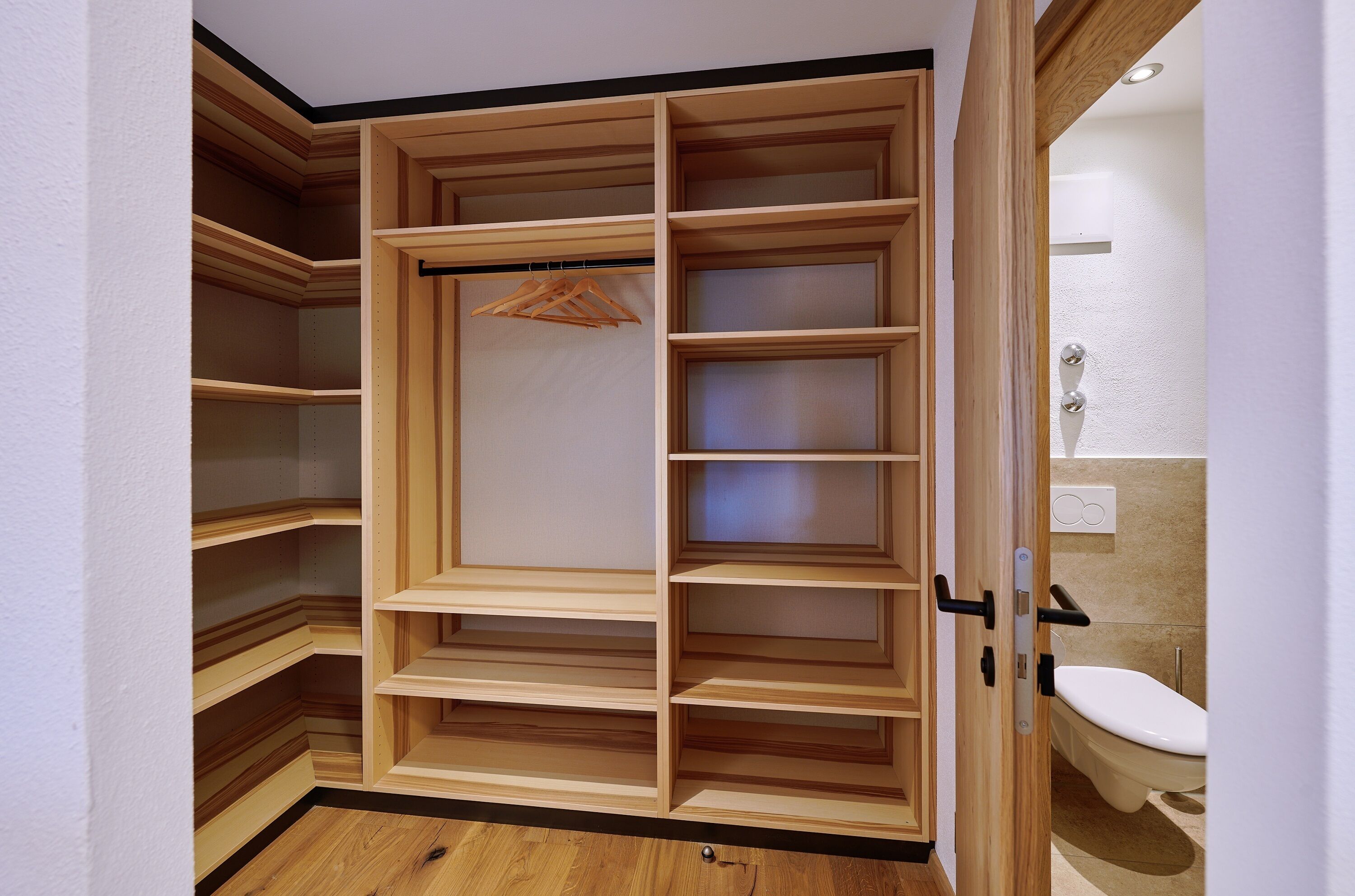 A walk-in closet with multiple shelves and hanging space.