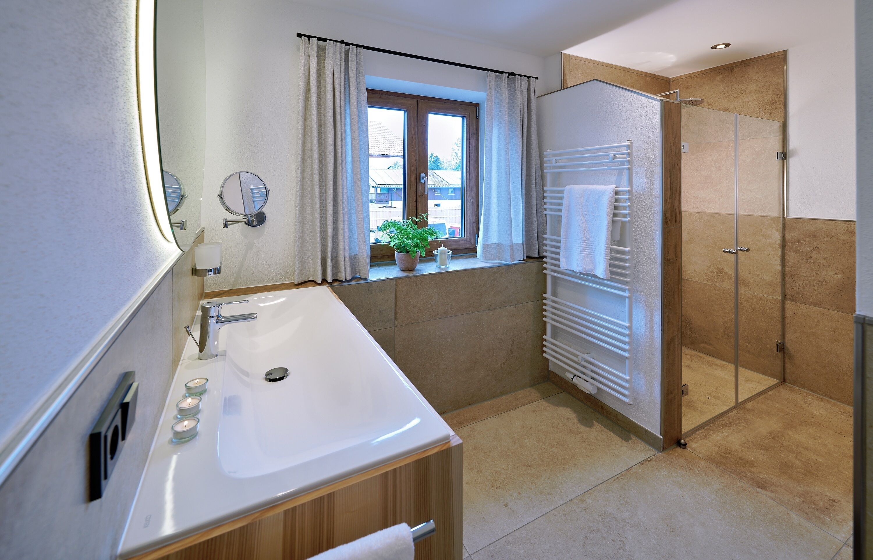 Ein modernes Badezimmer mit Waschbecken, Spiegel und Dusche.