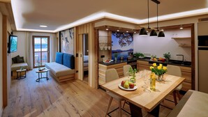 A modern living space with a dining area, kitchen, and a sofa with a view.