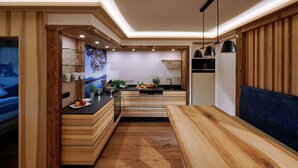 A modern kitchen with wooden cabinetry, a central island, and a dining area with a blue sofa.