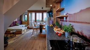 Eine moderne Küche mit Essbereich, Holzboden und einem großen Fenster.