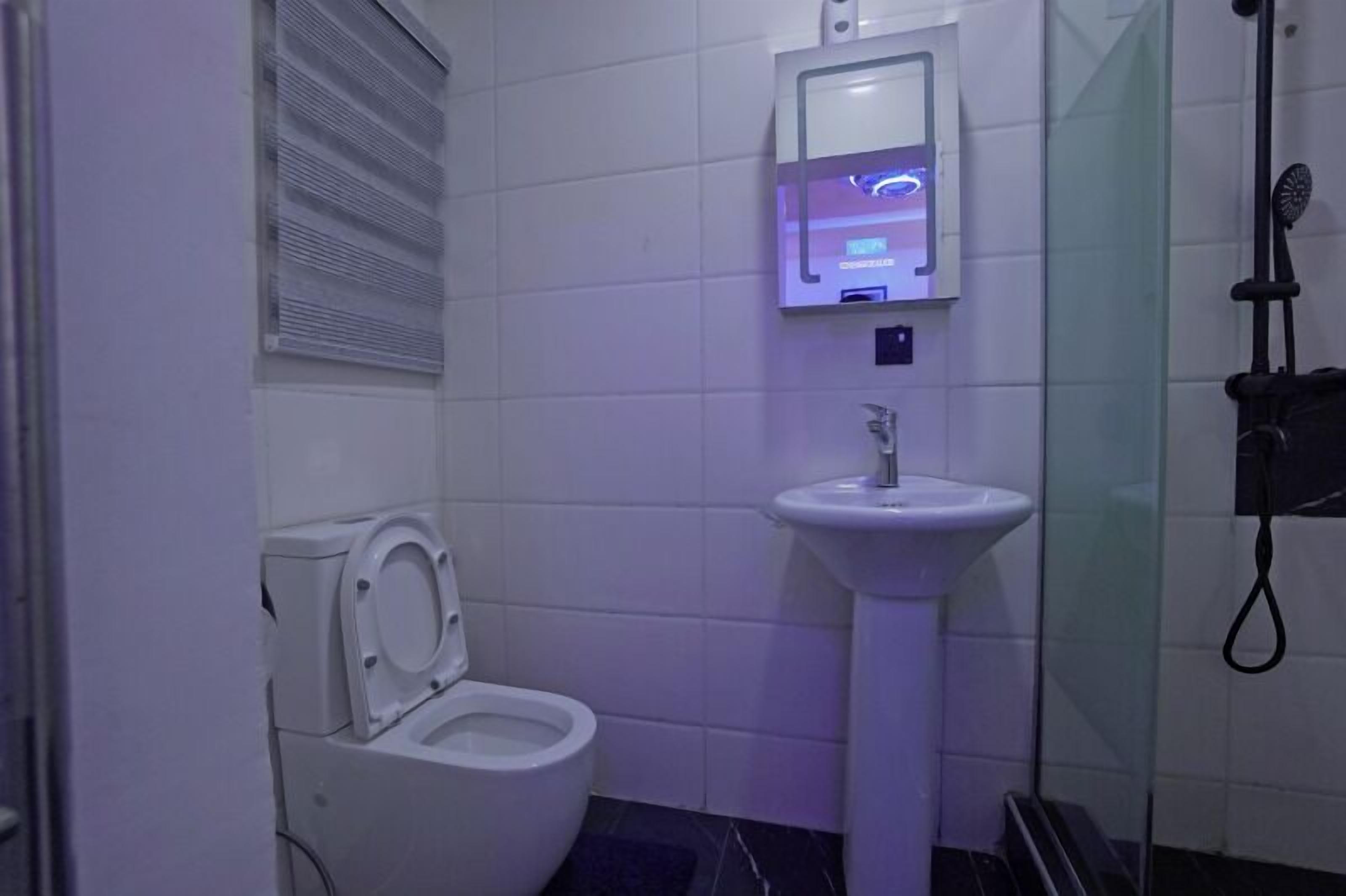A bathroom with a toilet, a sink, and a shower.