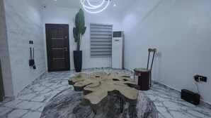 A modern interior with a unique wooden coffee table, a potted plant, and a drum. - 3H Villas Hotel & Luxury Apartment (Lekki)