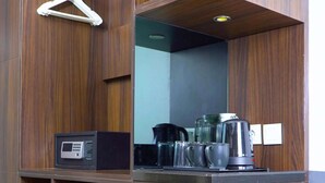 Een compacte kitchenette met een GEA-koelkast, een koffiezetapparaat en een waterkoker.