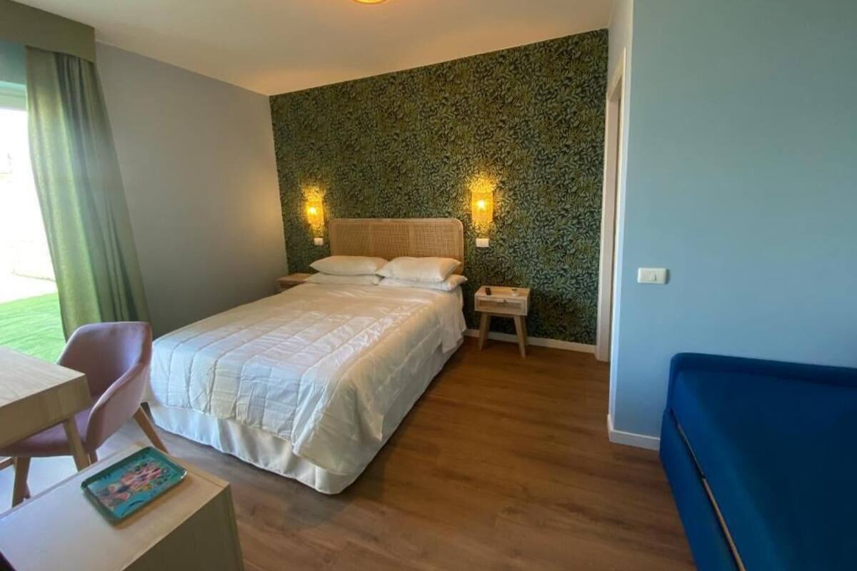 Ein Schlafzimmer mit Bett, Nachttischen, Schreibtisch und Stuhl.