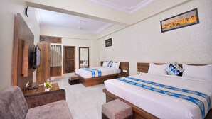 Une chambre d’hôtel avec deux lits, un bureau, une chaise, une armoire et une salle de bain.