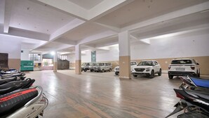 Un vaste espace de stationnement intérieur pouvant accueillir de nombreux véhicules, notamment des voitures et des motos, ainsi que quelques vélos.