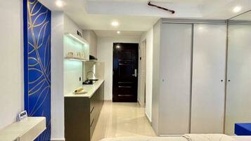 A modern hotel room with a bed, a desk, and a wardrobe.