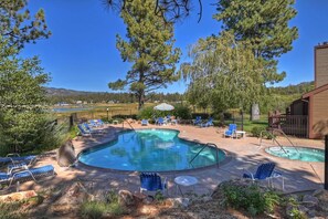 Una piscina con diverse sezioni, circondata da sdraio e un pontile in legno.