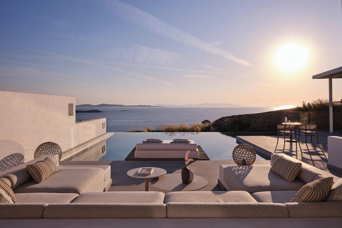 Un espace extérieur moderne, aménagé avec des sièges et une piscine, offrant une vue panoramique sur l’océan.