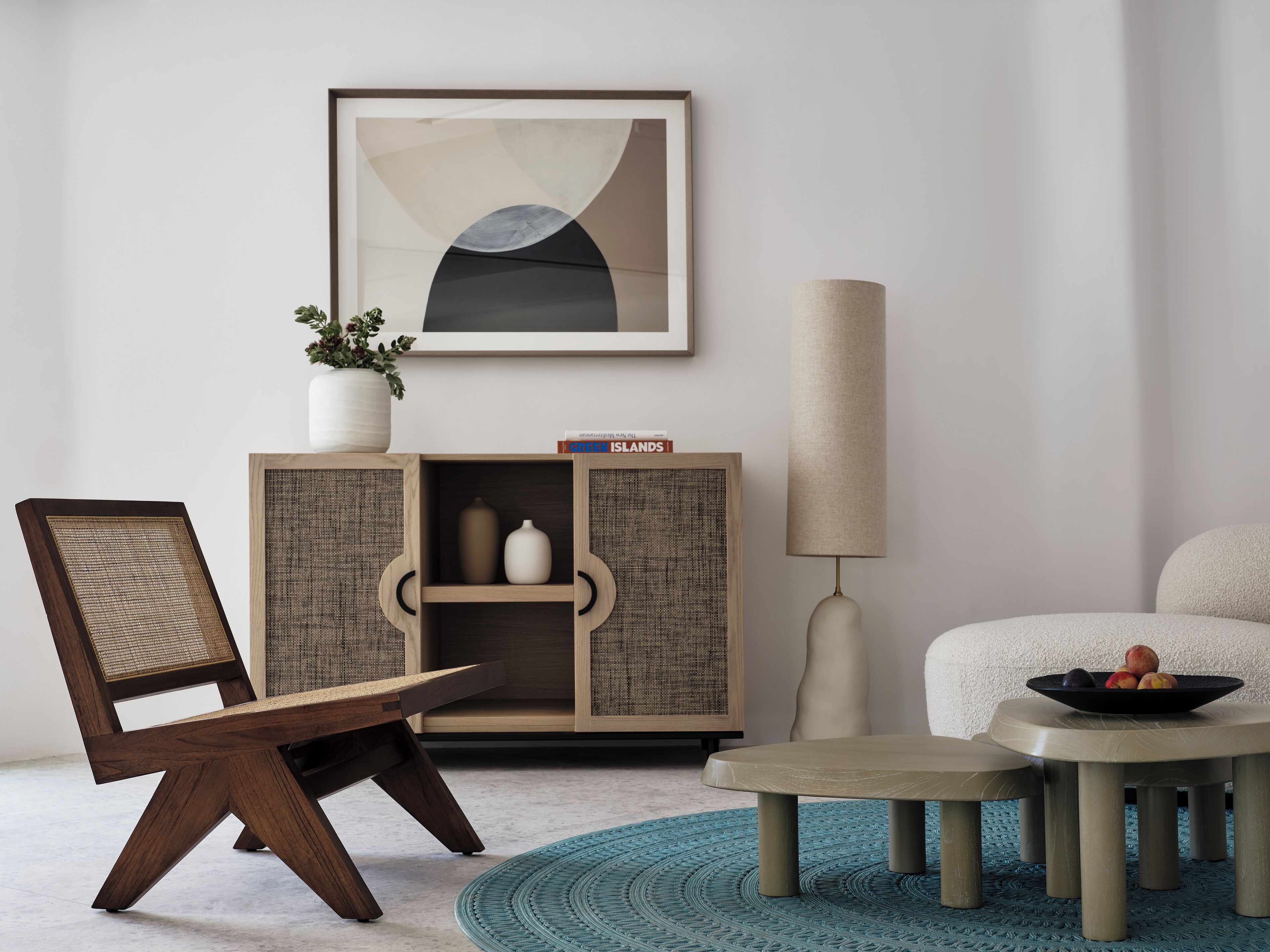 Un salon moderne comprenant une chaise en bois, un canapé, une table basse ronde, un meuble décoratif et un grand tableau abstrait accroché au mur.