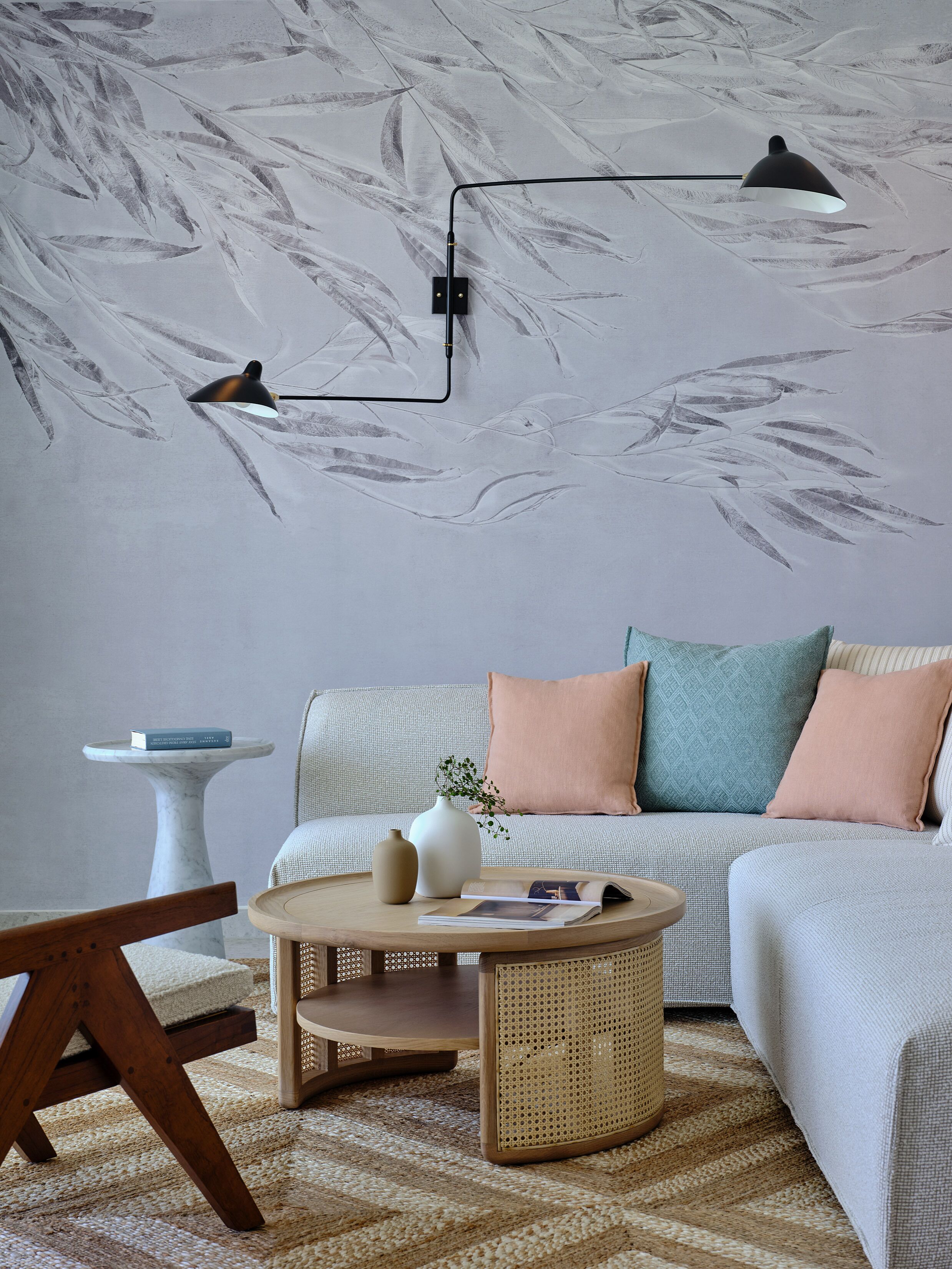 A cozy living room with a sofa, a coffee table, and a wall-mounted lamp.