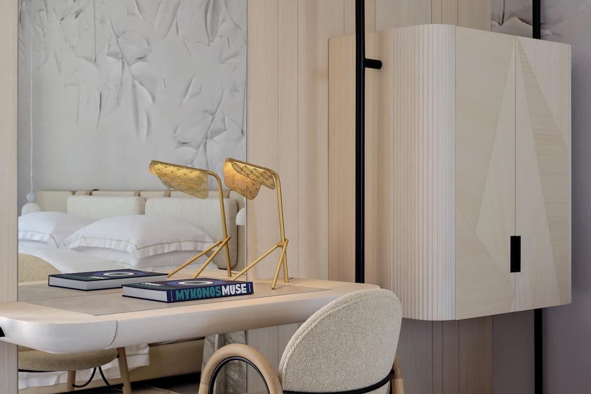 Une chambre moderne avec un lit, un bureau avec des livres et une grande armoire.