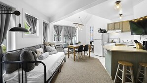Een modern appartement met een woongedeelte, eethoek en keuken.